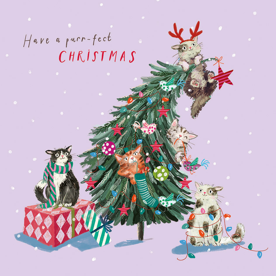 Square Christmas card featuring playful cats decorating a festive tree against a light purple background.